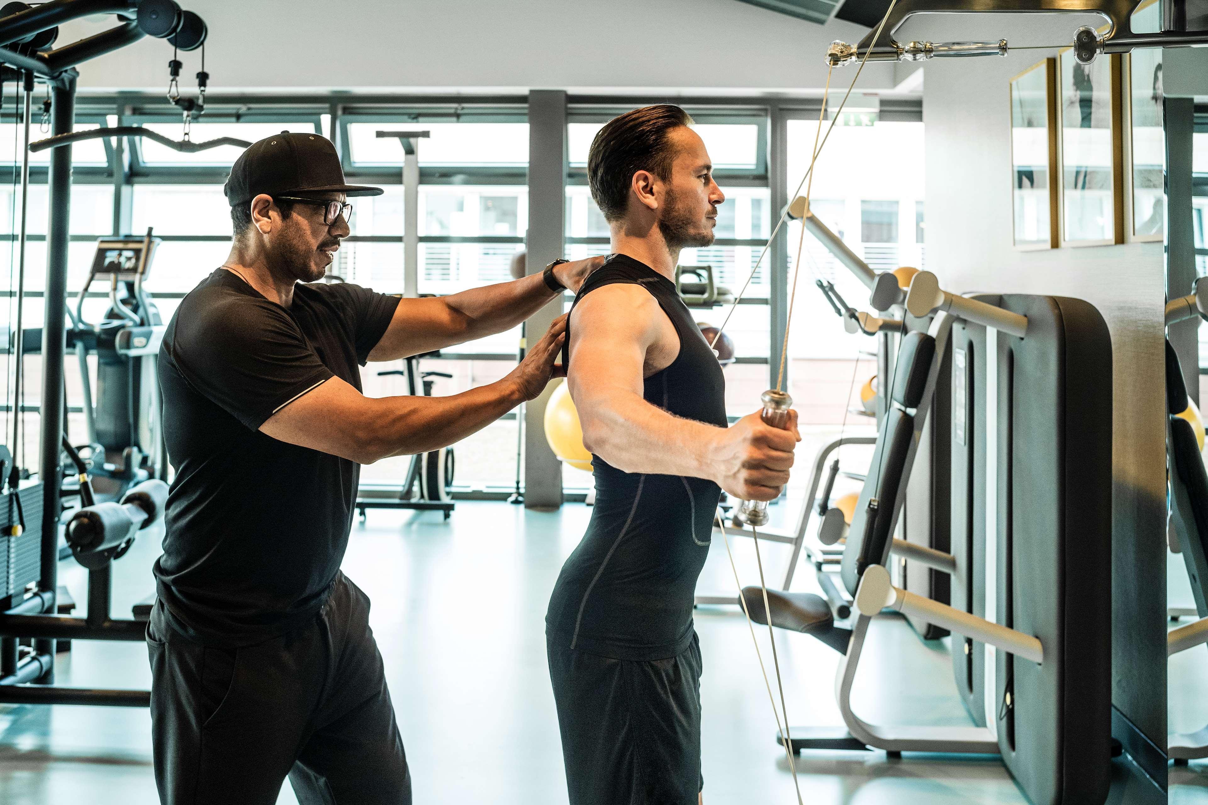Grand Hyatt Berlin Hotel Екстериор снимка Personal trainer assisting a man with a workout